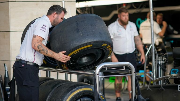 A Mercedes mechanic inspects a tire ahead of the Qatar...