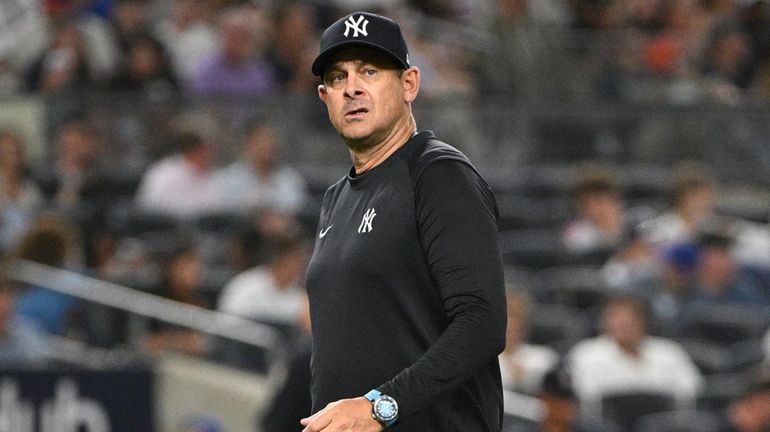 Yankees manager Aaron Boone walks to the dugout after a...