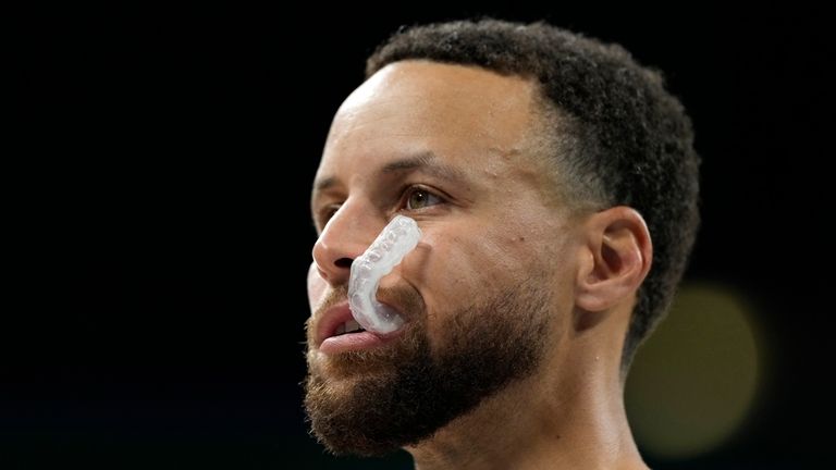 Stephen Curry, of the United States, stands on the court...