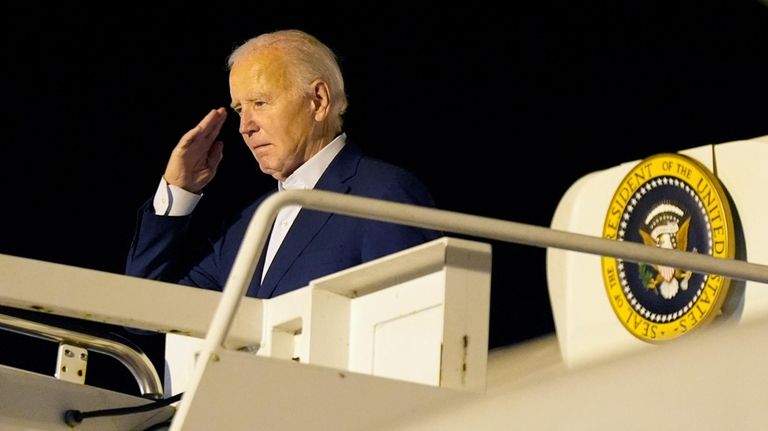 President Joe Biden salutes as he boards Air Force One...