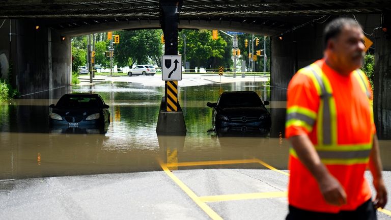 A tow truck operator responds to submerged vehicles at an...