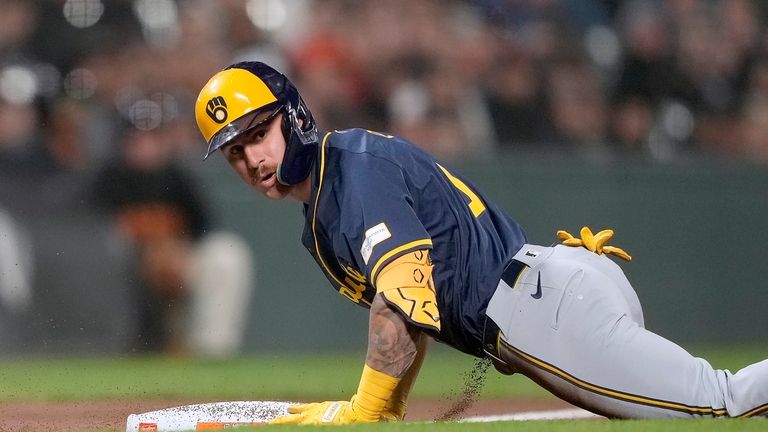 Milwaukee Brewers' Joey Ortiz slides into third base after hitting...