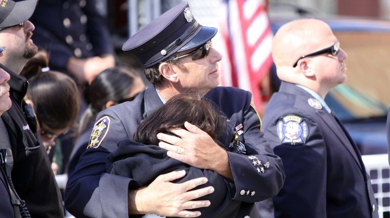 Long Beach volunteer firefighter and resident Lawrence Mazel comforts his...