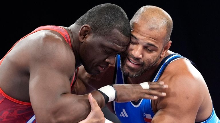 Cuba's Mijain Lopez and Chile's Yasmani Acosta Fernandez, right, compete...