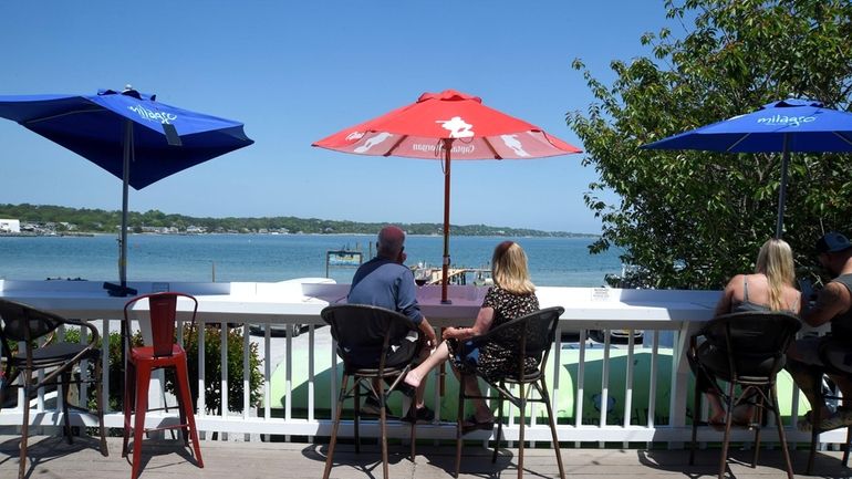 Patrons take in the water views at Rumba’s Restaurant in...