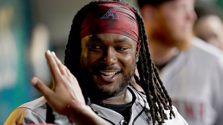 Arizona Diamondbacks' Josh Bell celebrates in the dugout after hitting...