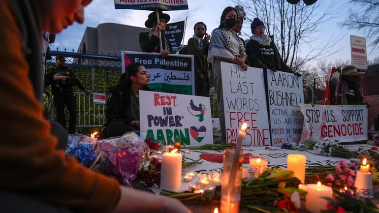 Demonstrators light candles during a vigil outside the Israeli Embassy,...