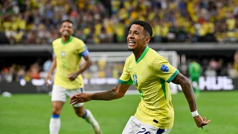 Brazil's Savinho celebrates scoring his side's second goal against Paraguay...