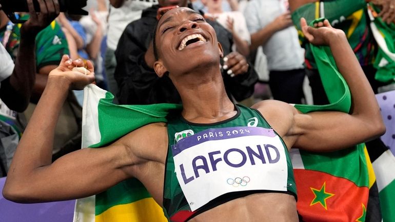 Thea Lafond, of Dominica, celebrates after winning the women's triple...