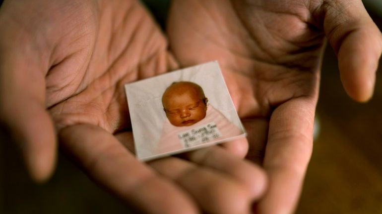 Robert Calabretta holds his baby photo from before he was...