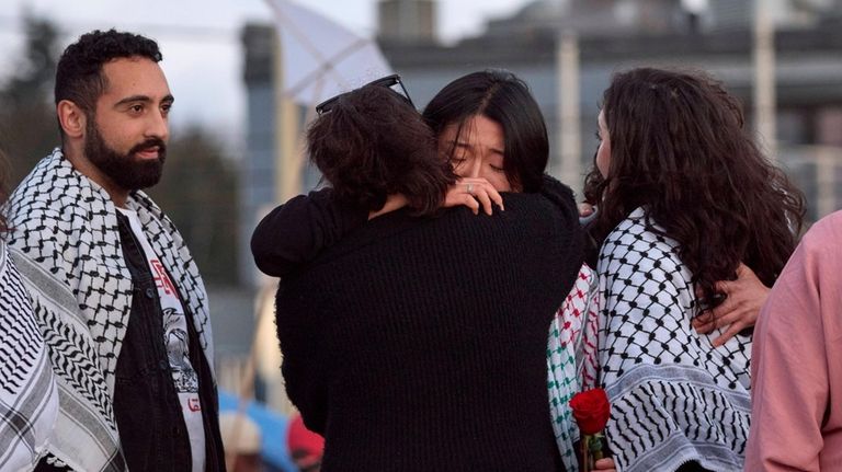 Sue Han, facing, is hugged after speaking of her friend,...