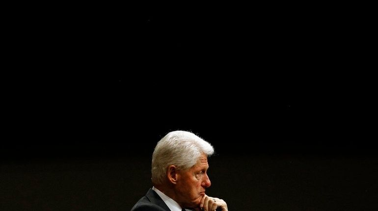 Former President Bill Clinton listens during a panel discussion.