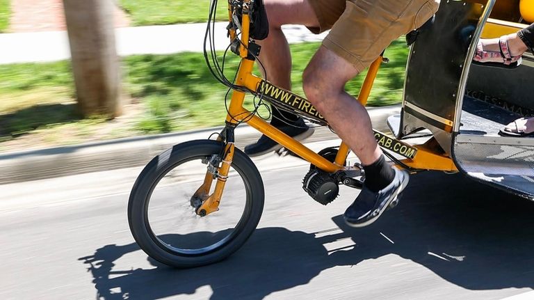 Justin Galbraith, owner of Fire Island Pedicab, drives a pedicab...