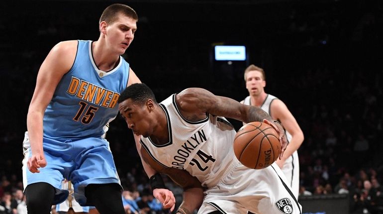 Nets' Rondae Hollis-Jefferson drives the ball against Nuggets' Nikola Jokic...