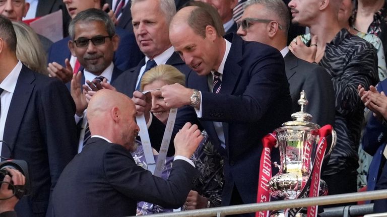 Manchester United's head coach Erik ten Hag, left, receives his...