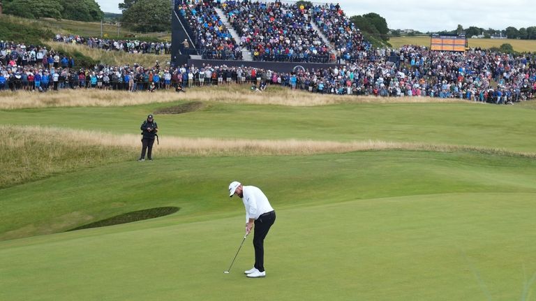 Shane Lowry of Ireland putts on the eighth green during...