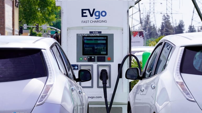 FILE — Electric cars are parked at a charging station...