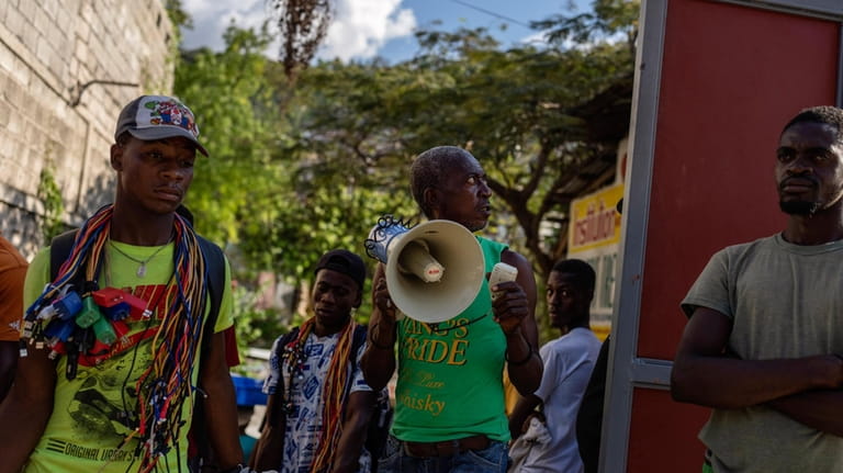 A resident uses a loudspeaker to ask neighbors for a...