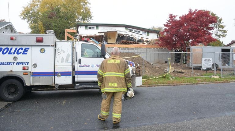 Firefighters and police at the scene of the collapsed house...