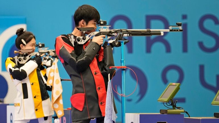 China's Sheng Lihao, right, and teammate Huang Yuting compete for...