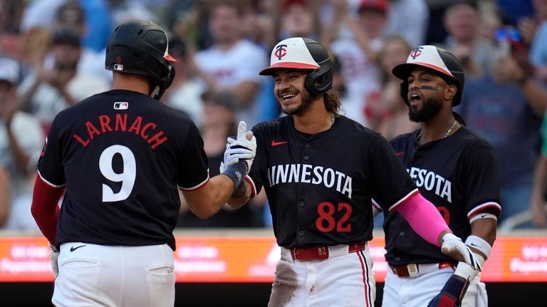 Minnesota Twins' Trevor Larnach celebrates with Austin Martin and Willi...