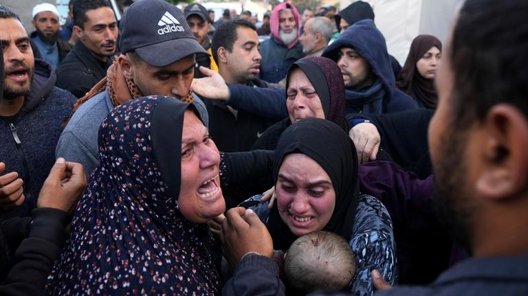 Palestinians mourn a baby killed in the Israeli bombardments of...