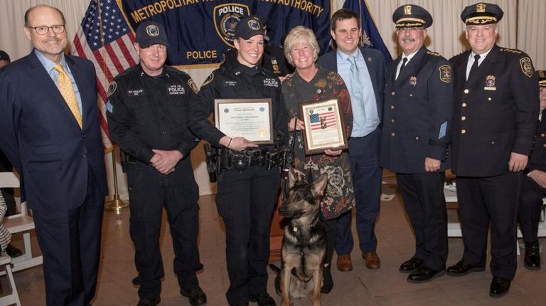 MTA Officer Alison Schmitt holds a certificate after she and...