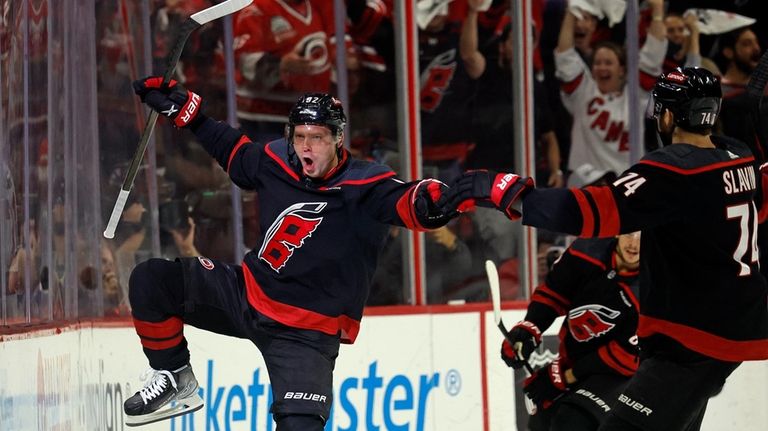 Carolina Hurricanes' Evgeny Kuznetsov, left, celebrates with Jaccob Slavin (74)...