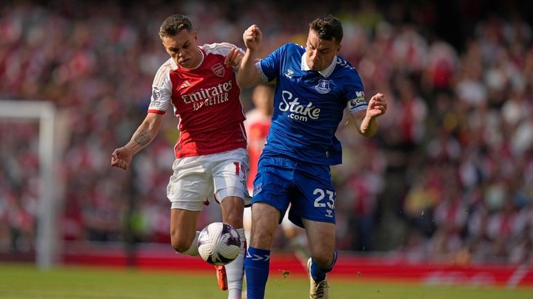 Arsenal's Leandro Trossard, left, and Everton's Seamus Coleman battle for...