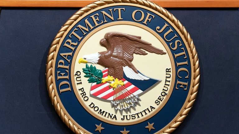 The Department of Justice seals is seen during a news...