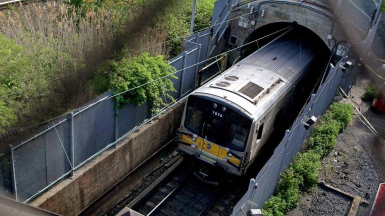 An LIRR train disappears into a tunnel westbound on the...