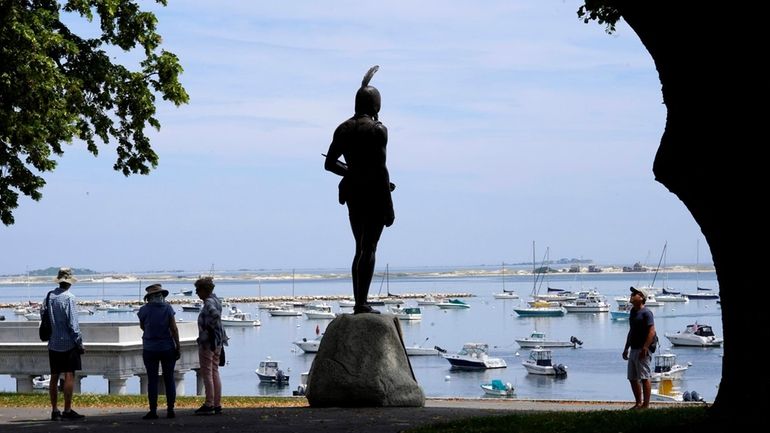 Visitors stand near a 1921 statue of the Wampanoag leader...