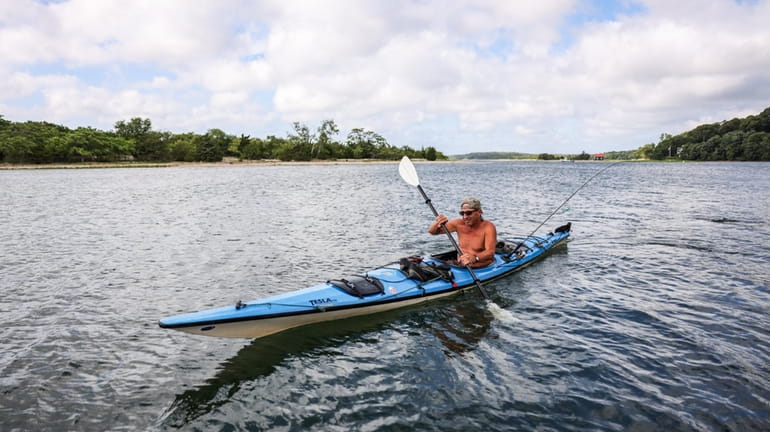Scott Bredes, of Ridge, kayaks through Stony Brook harbor in...