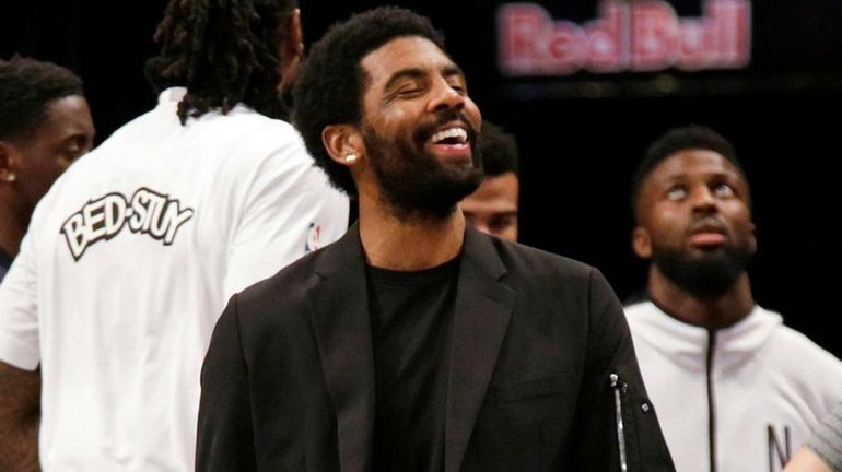 Nets guard Kyrie Irving, center, jokes with forward Kevin Durant,...