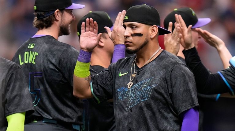 Tampa Bay Rays' Isaac Paredes celebrates with teammates, including Josh...