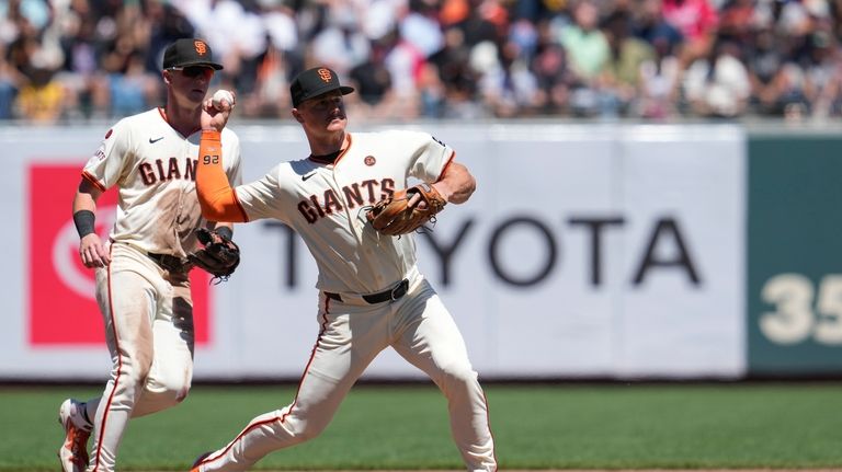 San Francisco Giants third baseman Matt Chapman, right, throws to...