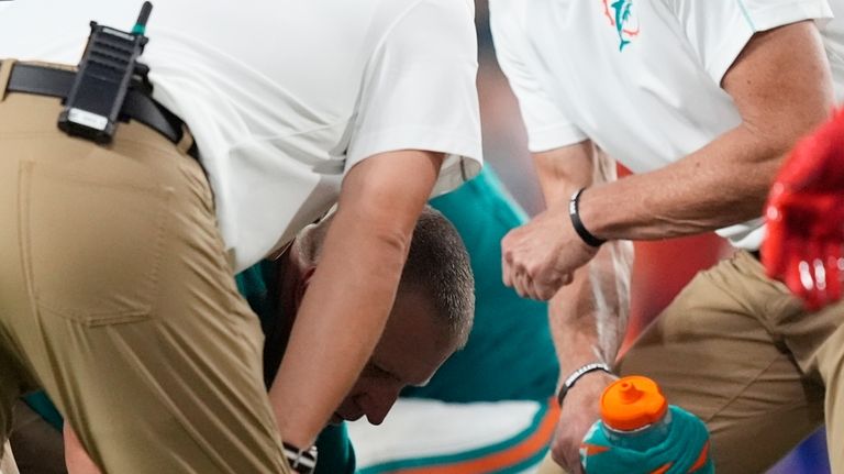 Miami Dolphins quarterback Tua Tagovailoa (1) lies on the field...