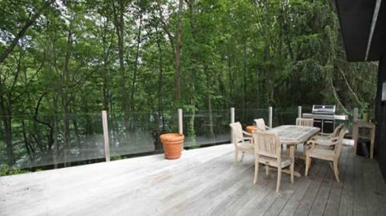 The deck outside a wooded Laurel Hollow property listed for...