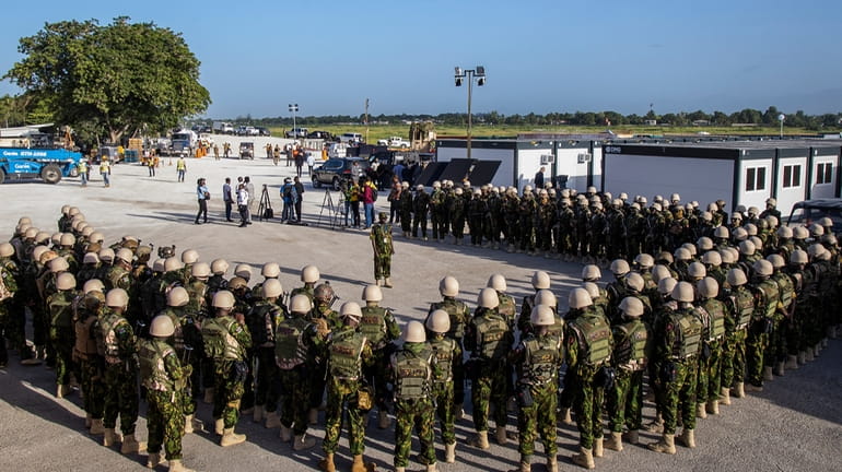 Kenyan police stand at their base during a visit by...