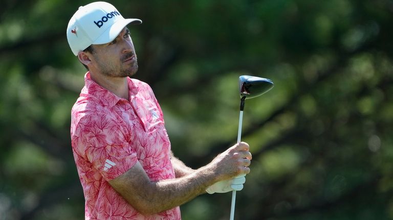 Nick Taylor, of Canada, watches his shot from the 17th...