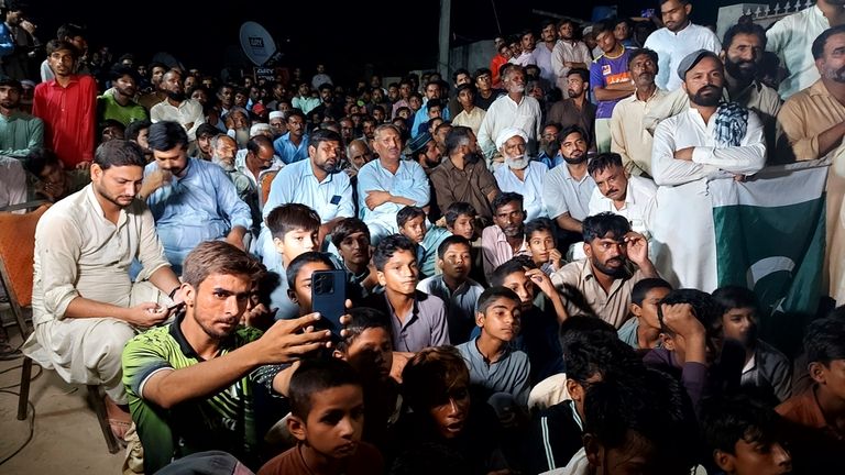 Pakistani people watch the final competes of Pakistan's Arshad Nadeem...