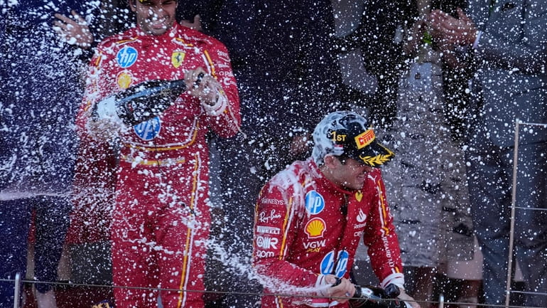 Ferrari driver Charles Leclerc of Monaco, right, celebrates on the...