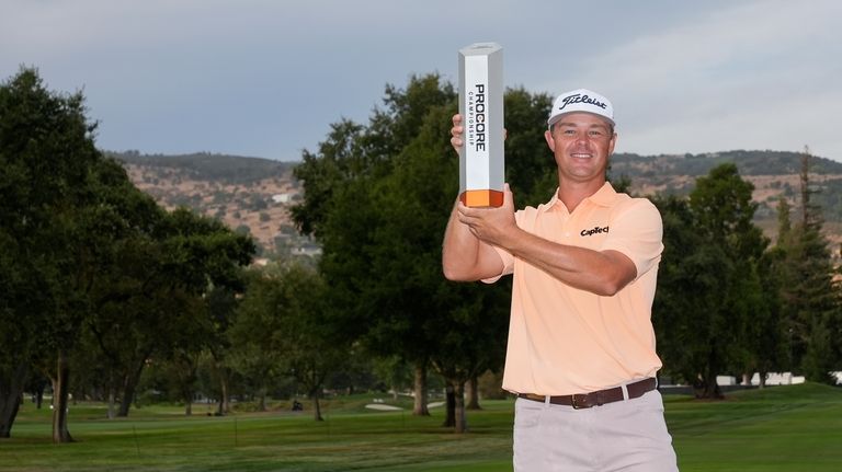 Patton Kizzire holds up the trophy after winning the Procore...