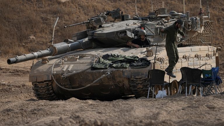 An Israeli soldier jumps from the top of a tank...