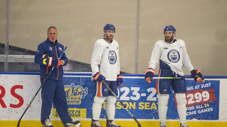 Edmonton Oilers' defensive coach Paul Coffey stands with Connor McDavid...