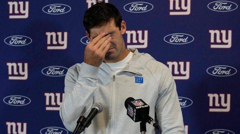 Giants quarterback Daniel Jones rubs his eyes during an NFL postgame me...