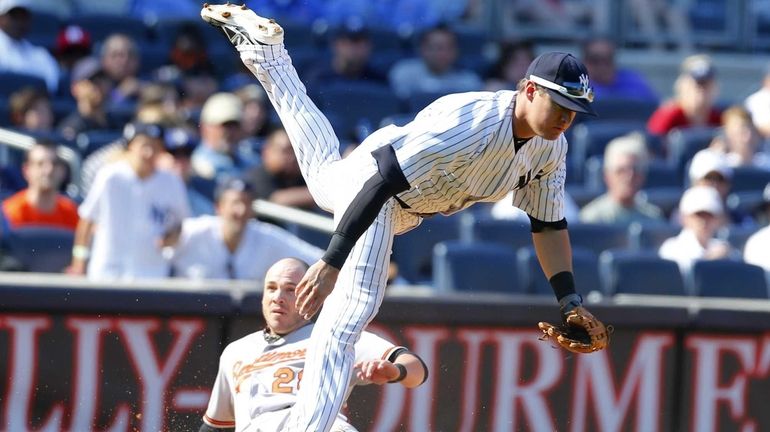 Kelly Johnson of the Yankees is tripped up by Steve...