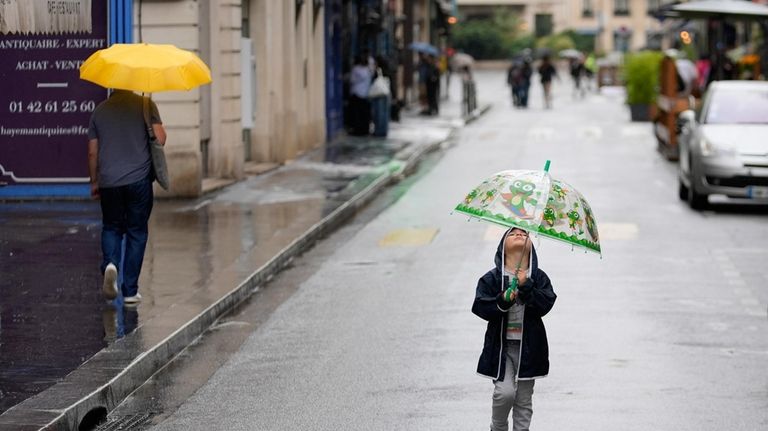 A child walks down a street still mostly closed to...