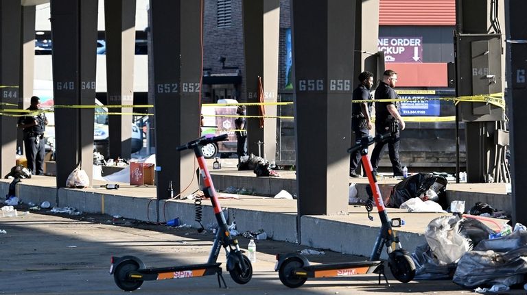 Officers stand behind police tape seen at the scene of...