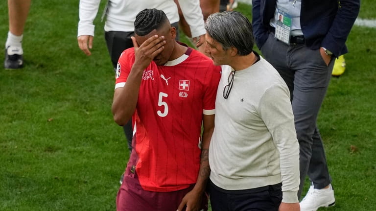 Switzerland's head coach Murat Yakin comforts Switzerland's Manuel Akanji after...